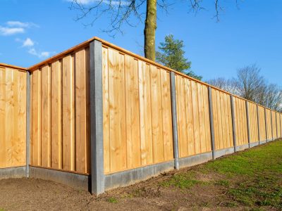 This image shows a fence that is made of both wood and concrete for extra support.